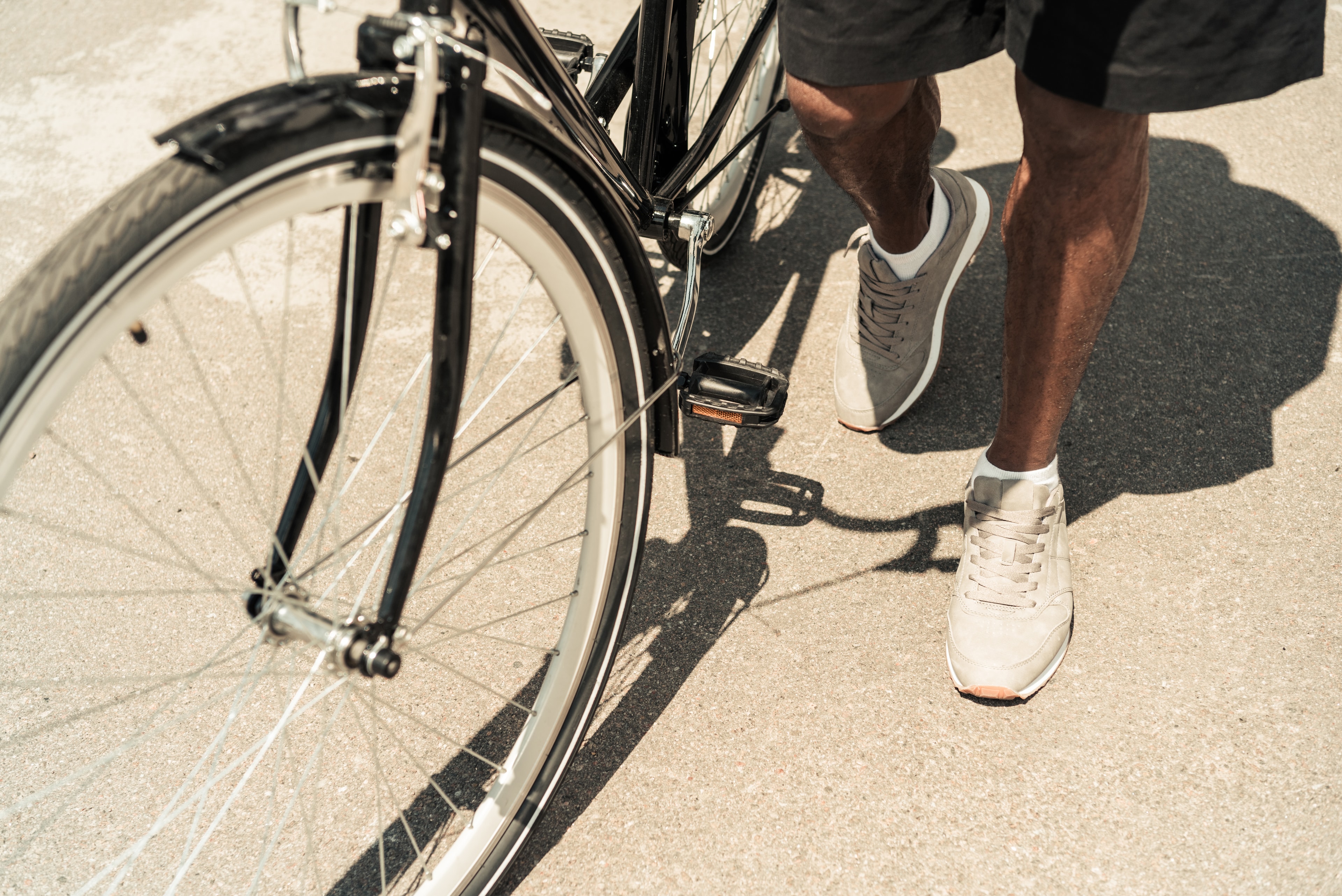 Person with a bicycle on a sunny street
