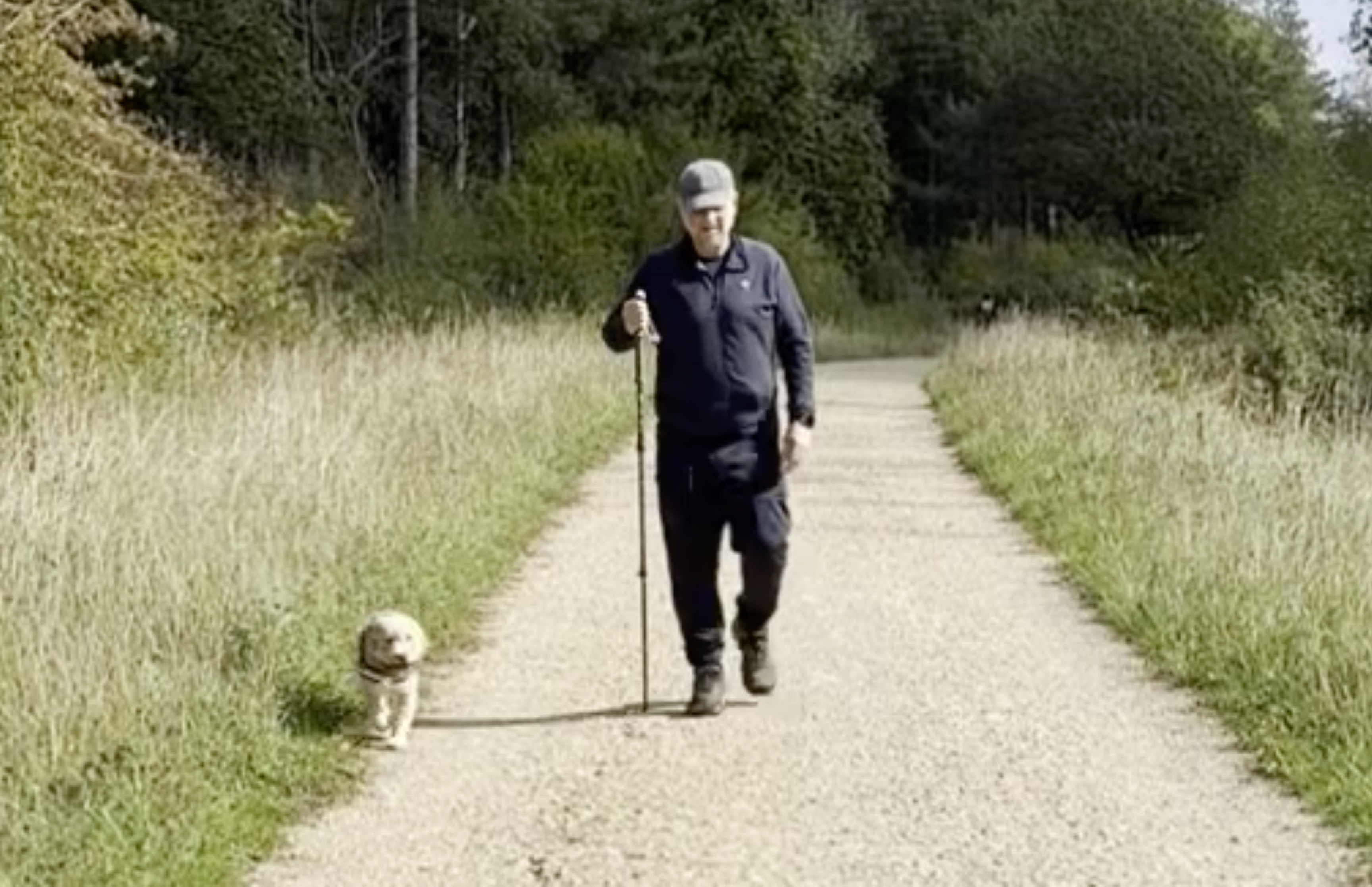 Paul-Austin and Woody walking together on a sunlit path on the Jurassic Way